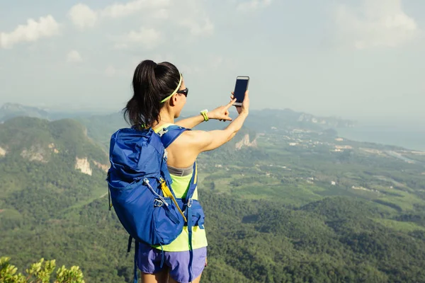 Mujer excursionista tomando fotos con el teléfono celular —  Fotos de Stock