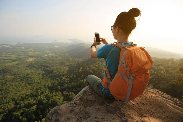 Mujer excursionista tomando fotos con el teléfono celular — Foto de Stock