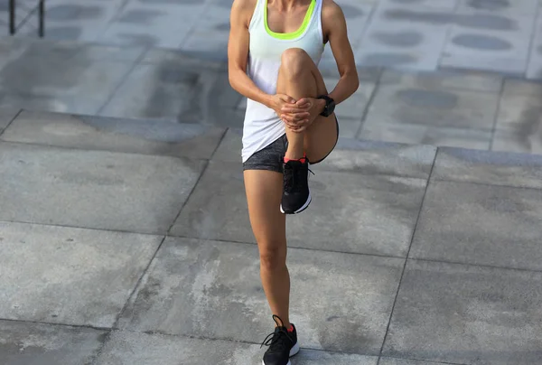 Frau wärmt sich vor Lauf auf — Stockfoto