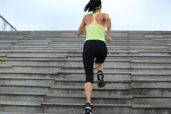 Молодая женщина бежит вверх по лестнице — стоковое фото