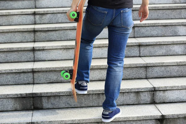 Skateboarder walking upstairs — Stock Photo, Image