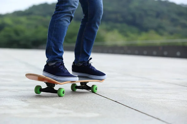 Jambes de skateboarder pratiquant en ville — Photo