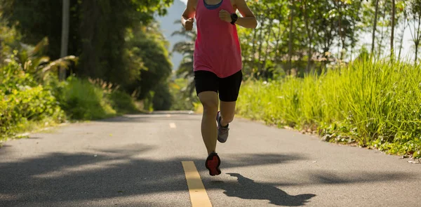 Jonge vrouw lopen bij bospad — Stockfoto