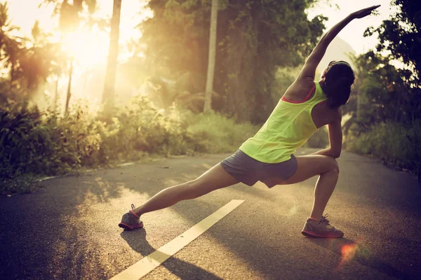 Jonge vrouwelijke atleet warming-up — Stockfoto