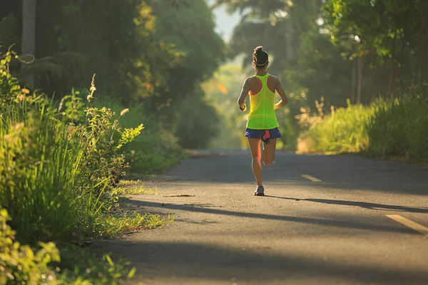 Jeune femme courant sur le sentier forestier — Photo