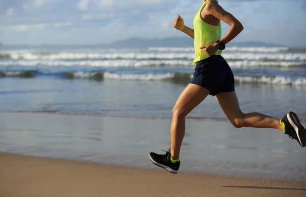 Mujer joven corriendo en la playa — Foto de Stock