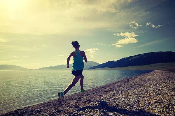 Mujer joven corriendo a la orilla del mar —  Fotos de Stock