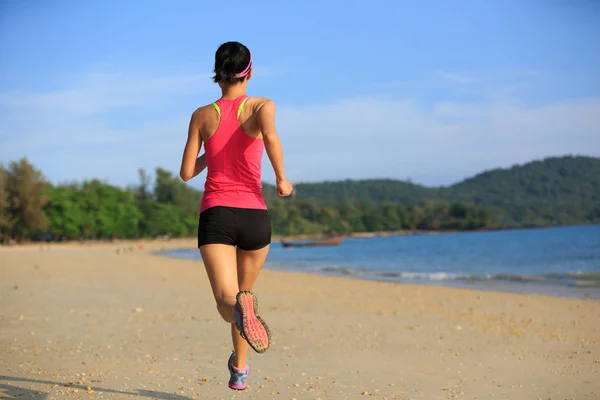 Jovem mulher correndo na praia de areia — Fotografia de Stock