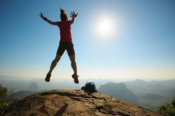 Frau springt auf Berggipfel — Stockfoto