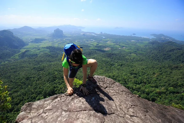 Ung kvinna backpacker klättra upp — Stockfoto