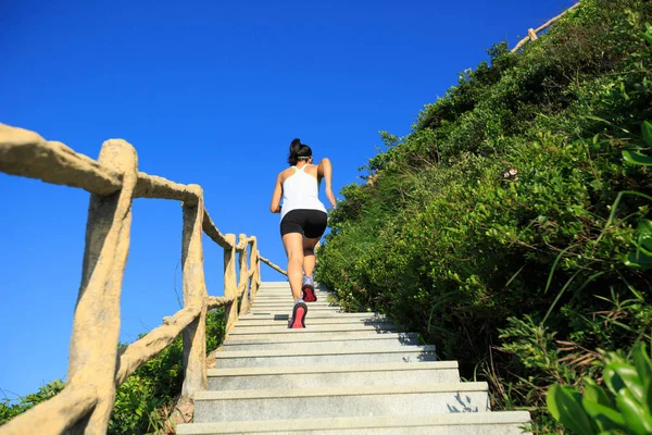 Woman running upstairs on stairs — Stock Photo, Image