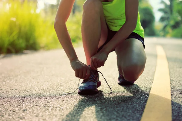 Mujer joven atando cordones — Foto de Stock