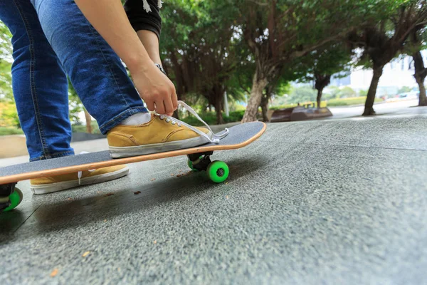 Mladý americký skateboardista vázání tkaničky — Stock fotografie