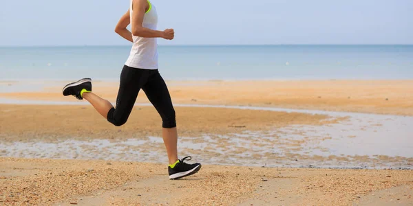 Jonge vrouw actief aan zandstrand — Stockfoto