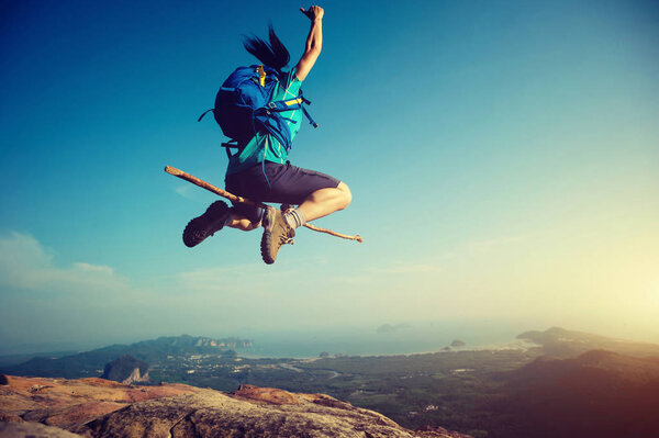 woman jumping on mountain top
