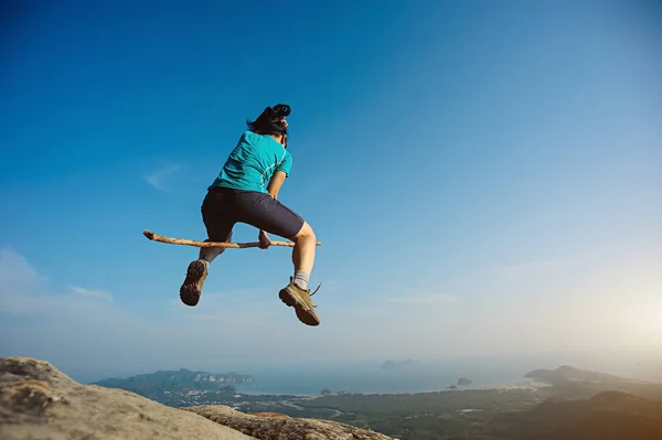 Mujer saltando en la cima de la montaña — Foto de Stock