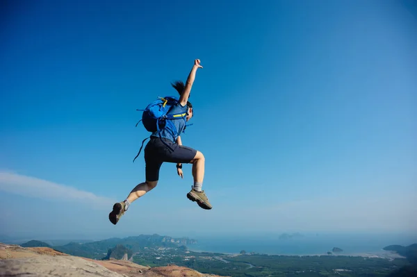 Ung kvinna hoppa på bergets topp — Stockfoto