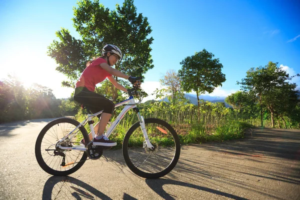 Mujer joven montando bicicleta de montaña — Foto de Stock