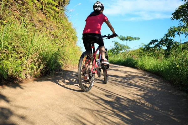 Dağ bisikleti süren genç bir kadın — Stok fotoğraf