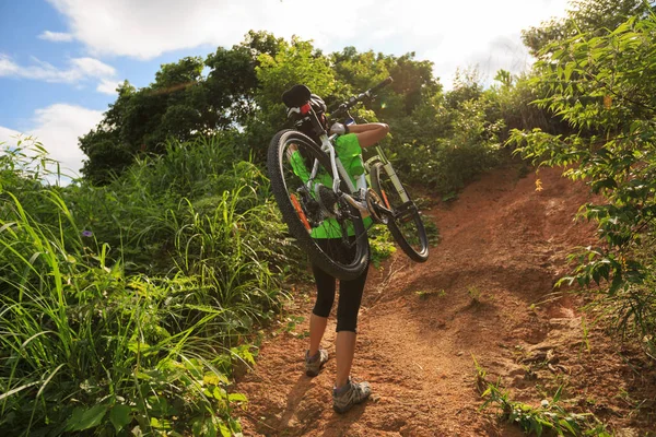 Mujer joven llevando bicicleta de montaña —  Fotos de Stock