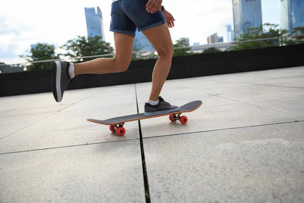 Mujer joven montando monopatín — Foto de Stock