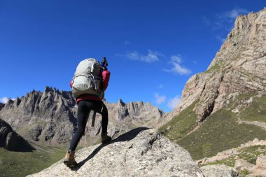 Dağlarda yürüyüş yapan genç bir kadın.  