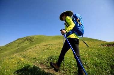 Dağlarda yürüyüş yapan genç bir kadın.