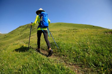 Dağlarda yürüyüş yapan genç bir kadın.