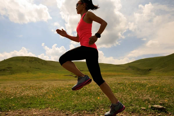 Young woman running on grassland trail — Stock Photo, Image