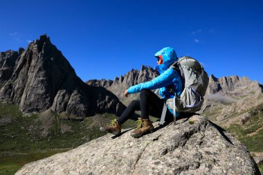 Dağlarda yürüyüş yapan genç bir kadın.  