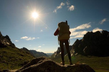 Dağlarda yürüyüş yapan genç bir kadın.  