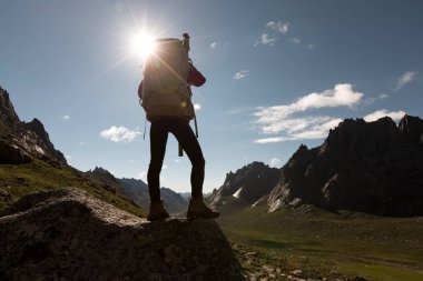 Dağlarda yürüyüş yapan genç bir kadın.  