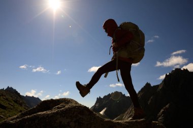 Dağlarda yürüyüş yapan genç bir kadın.  