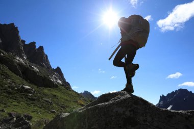 Dağlarda yürüyüş yapan genç bir kadın.  