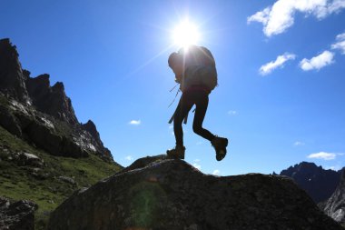 Dağlarda yürüyüş yapan genç bir kadın.  