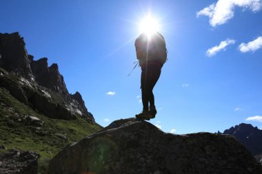 Dağlarda yürüyüş yapan genç bir kadın.  