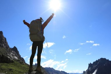 Dağlarda yürüyüş yapan genç bir kadın.  