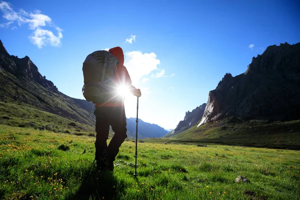 Dağlarda yürüyüş yapan genç bir kadın.  