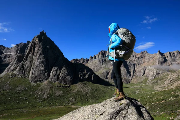 Dağlarda yürüyüş yapan genç bir kadın.  
