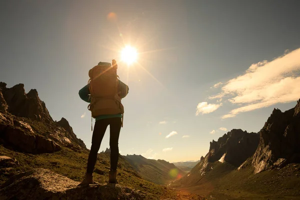 Dağlarda yürüyüş yapan genç bir kadın.  