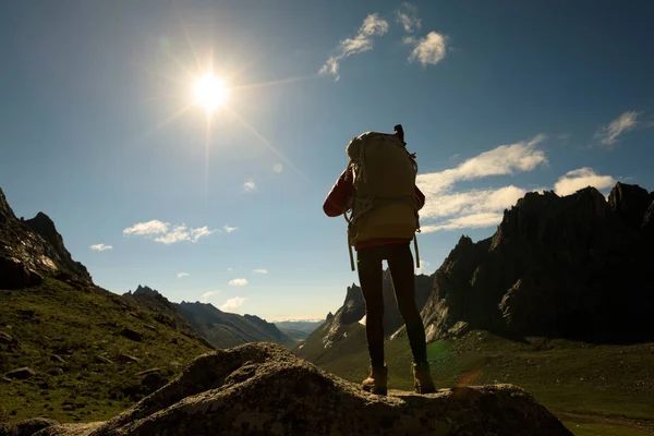 Dağlarda yürüyüş yapan genç bir kadın.  