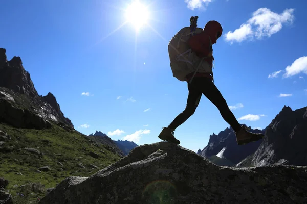 Dağlarda yürüyüş yapan genç bir kadın.  