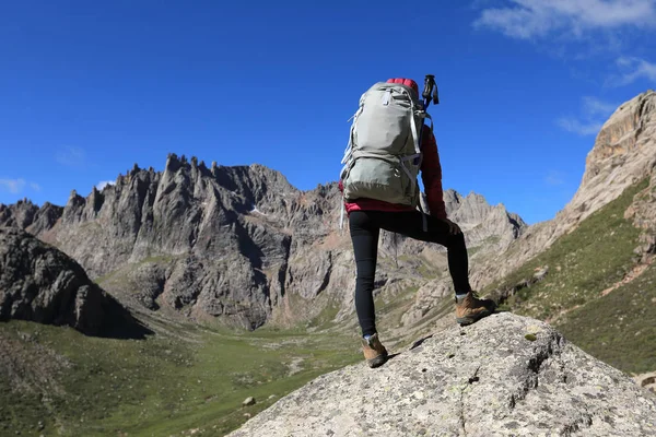 Dağlarda yürüyüş yapan genç bir kadın.  