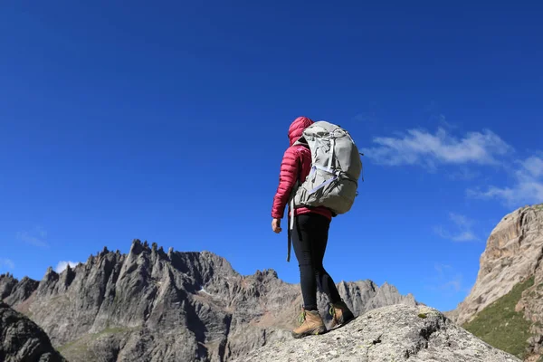 Dağlarda yürüyüş yapan genç bir kadın.  