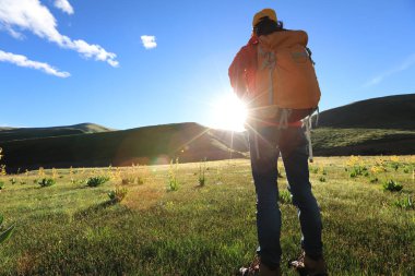 Dağlarda yürüyüş yapan genç bir kadın.