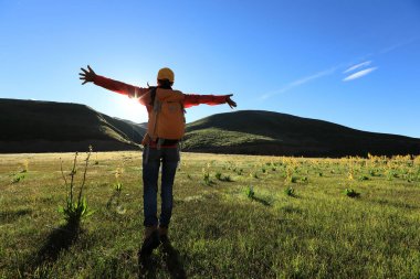 Dağlarda yürüyüş yapan genç bir kadın.