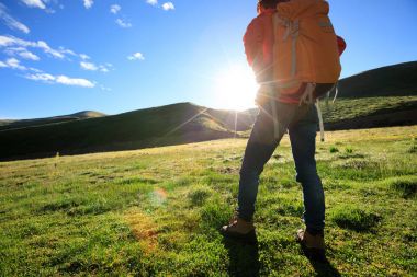 Dağlarda yürüyüş yapan genç bir kadın.