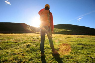 Dağlarda yürüyüş yapan genç bir kadın.