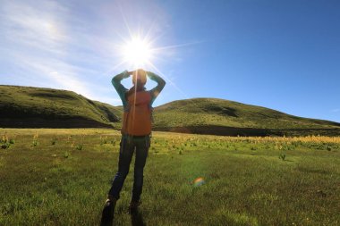 Dağlarda yürüyüş yapan genç bir kadın.