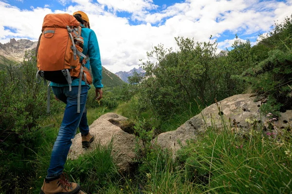 Dağlarda yürüyüş yapan genç bir kadın.